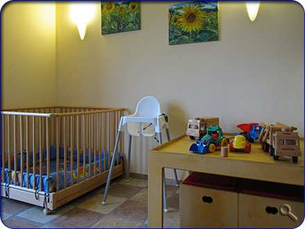 Ger&auml;umige Spielecke mit Krabbelbox und Holzspielzeug im Wohnzimmer