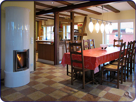 Kamin im Wohnzimmer mit Blick auf den gro&szlig;en E&szlig;tisch